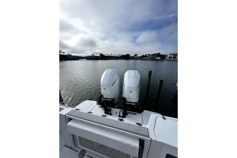 Slide: The Image of 2026 Blackfin 332 CC boat with dual Mercury engines on a calm waterfront. - 12
