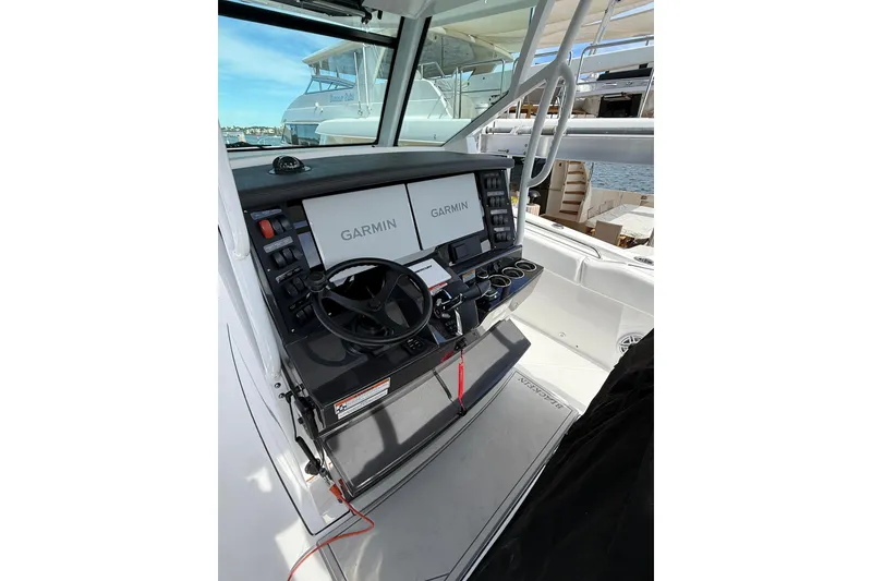 Slide: The Image of 2026 Blackfin 332 CC boat helm with dual Garmin displays and steering wheel. - 16