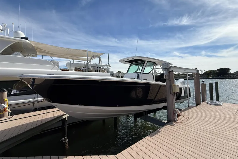 Slide: The Image of 2026 Blackfin 332 CC boat docked under a clear blue sky. - 2