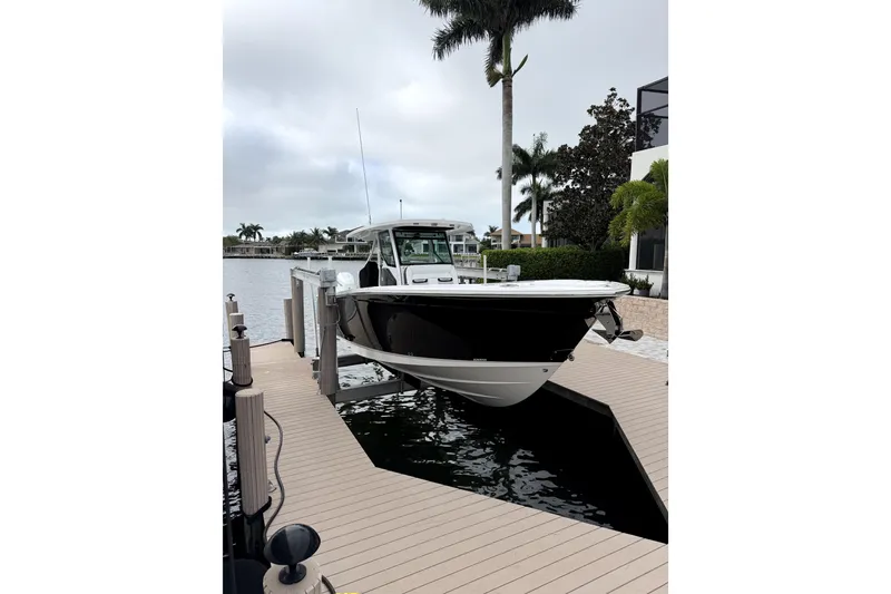 Slide: The Image of 2026 Blackfin 332 CC boat docked by waterfront with palm trees. - 3