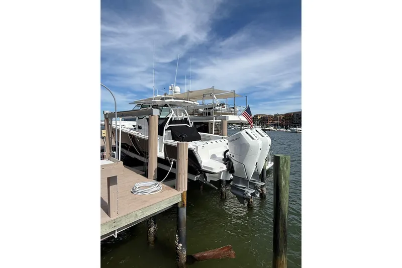 Slide: The Image of 2026 Blackfin 332 CC boat docked with twin Mercury engines and American flag. - 5