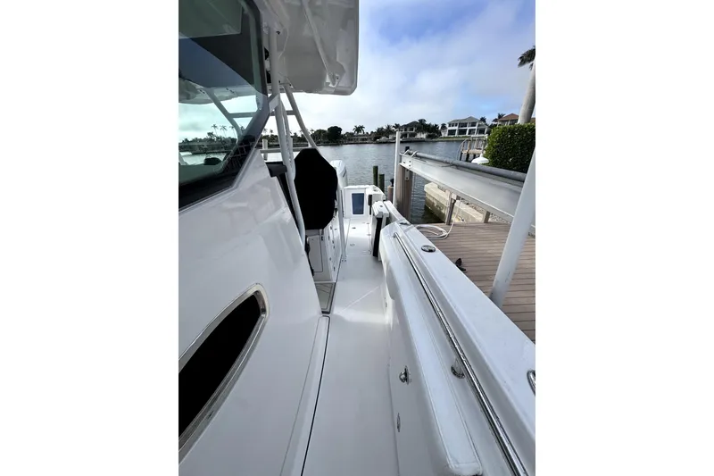 Slide: The Image of 2026 Blackfin 332 CC boat docked by waterfront homes. - 7