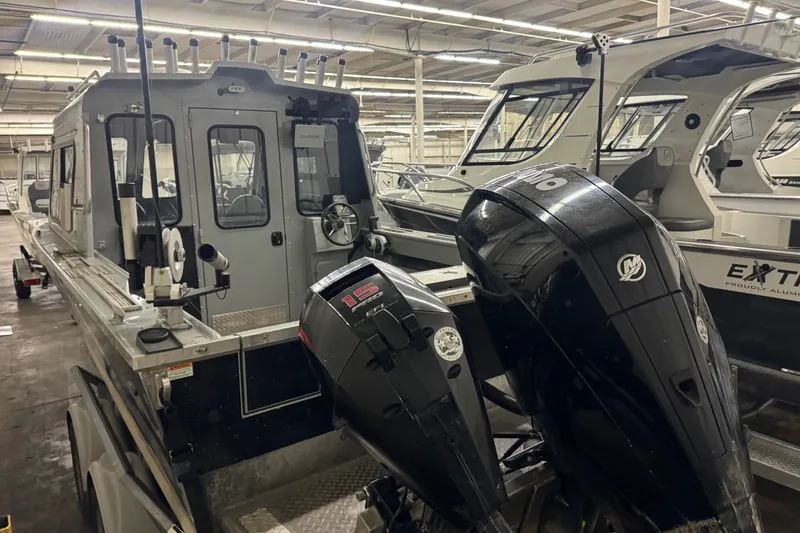 Slide: The Image of 2019 Hewescraft 220 Ocean Pro ET Hard Top boat with dual outboard motors in a showroom. - 16