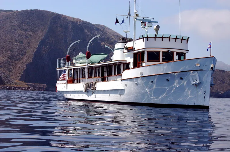 Slide: The Image of Classic 1946 J.M. Martinac yacht near rocky coastline. - 5