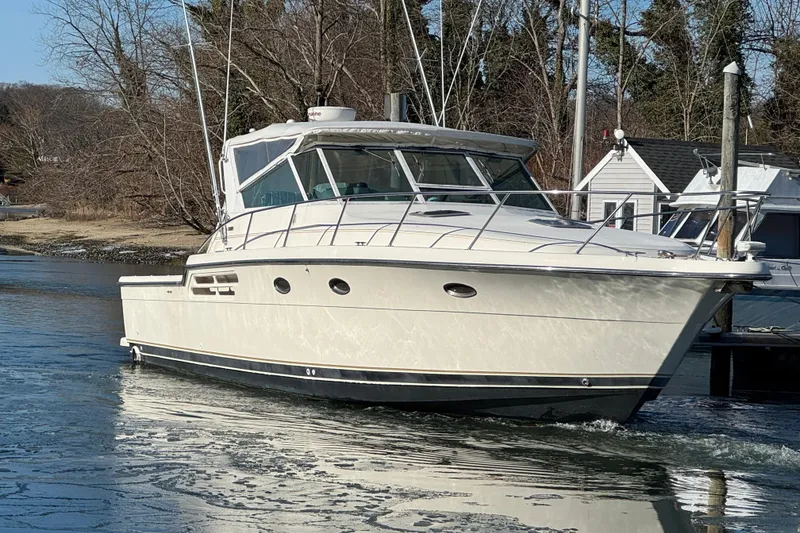 The Image of 1998 Tiara Yachts 4100 Open cruising on a calm waterway near a dock. - 0