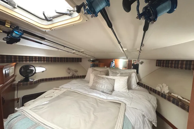 Slide: The Image of 1998 Tiara Yachts 4100 Open cabin with fishing rods and cozy bedding. - 15