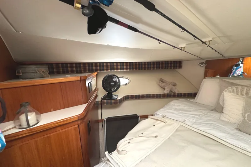 Slide: The Image of Cozy cabin interior of 1998 Tiara Yachts 4100 Open with bed and fishing rods. - 16