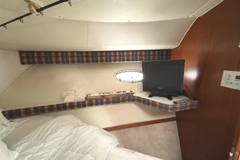 Slide: The Image of 1998 Tiara Yachts 4100 Open cabin interior with TV, shelf, and porthole window. - 17