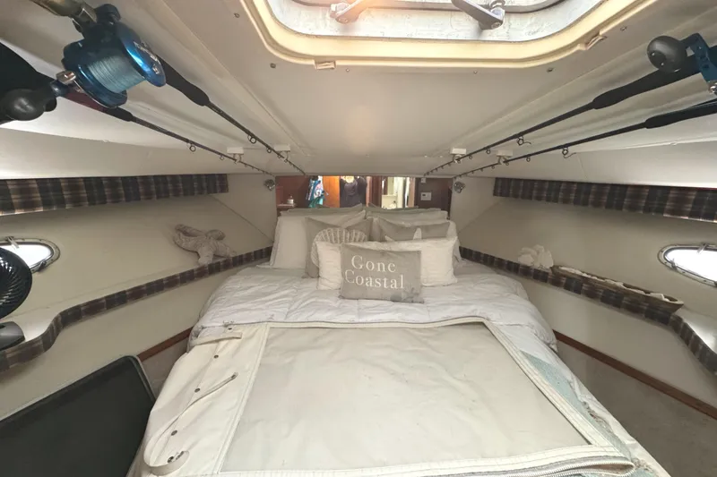 Slide: The Image of Cozy cabin interior of 1998 Tiara Yachts 4100 Open with plush bedding and fishing rods. - 18