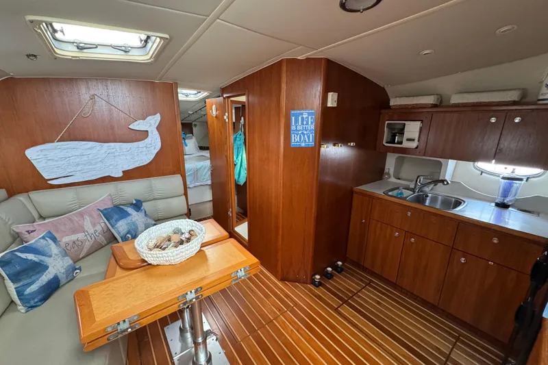 Slide: The Image of 1998 Tiara Yachts 4100 Open interior with wooden cabinetry and cozy seating area. - 8