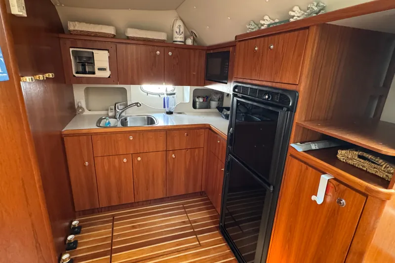 Slide: The Image of 1998 Tiara Yachts 4100 Open kitchen with wooden cabinetry and modern appliances. - 9