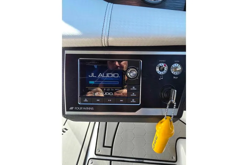 Slide: The Image of 2020 Four Winns HD270 RS boat on trailer, sunny day, palm trees in background. - 12