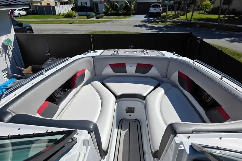 Slide: The Image of 2020 Four Winns HD270 RS boat on trailer, black and red design, sunny day. - 13