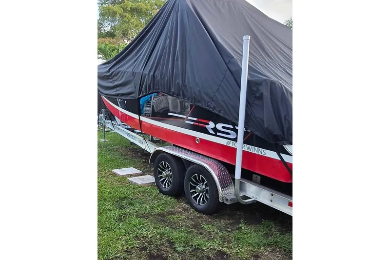 Slide: The Image of 2020 Four Winns HD270 RS boat with sleek design and spacious deck under clear blue sky. - 18