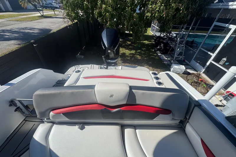 Slide: The Image of 2020 Four Winns HD270 RS boat interior with red and gray seating, outdoor setting. - 30