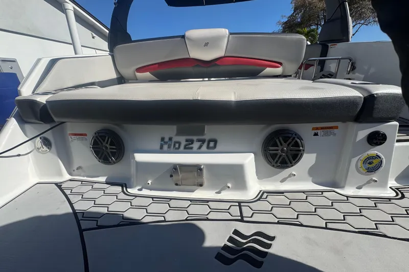 Slide: The Image of 2020 Four Winns HD270 RS boat rear seating area with speakers and logo. - 36