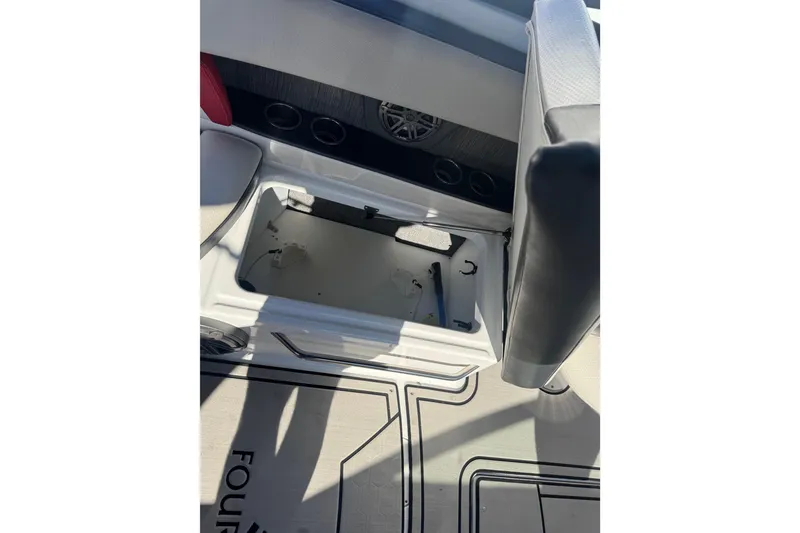 Slide: The Image of 2020 Four Winns HD270 RS boat interior with open storage compartment and speaker. - 41