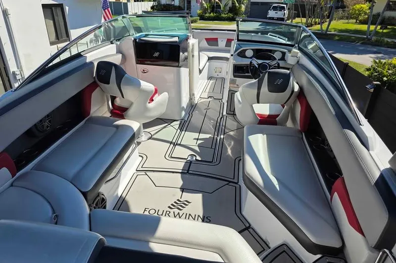 Slide: The Image of 2020 Four Winns HD270 RS boat with Mercury engine, parked on grass. - 5