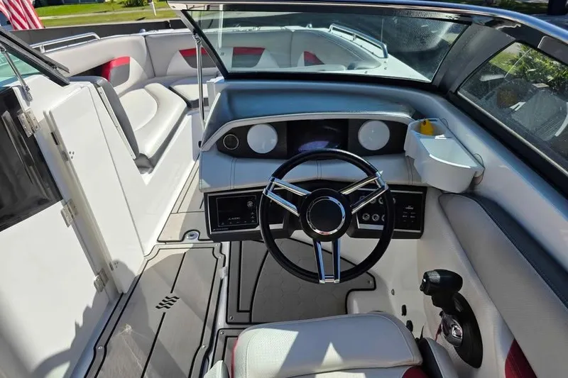 Slide: The Image of 2020 Four Winns HD270 RS boat on trailer, red and black hull, parked on grass. - 8