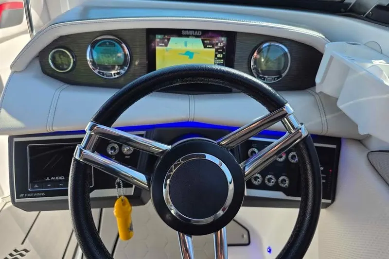 Slide: The Image of 2020 Four Winns HD270 RS boat on trailer, red hull, outdoor setting. - 9