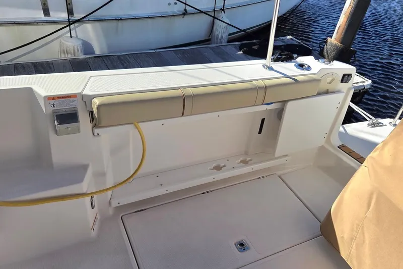 Slide: The Image of 2022 Ranger Tugs R-27 boat deck with covered seating, overlooking calm water. - 12