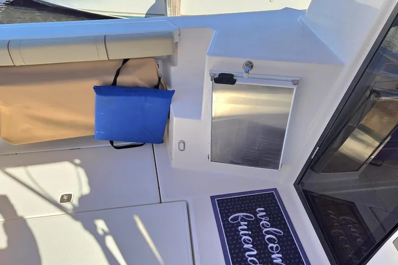 Slide: The Image of 2022 Ranger Tugs R-27 kitchen with stove, sink, and wooden cabinetry. - 14