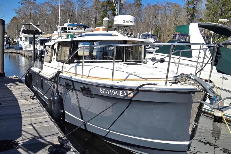 Slide: The Image of 2022 Ranger Tugs R-27 boat docked at marina, surrounded by other vessels. - 2