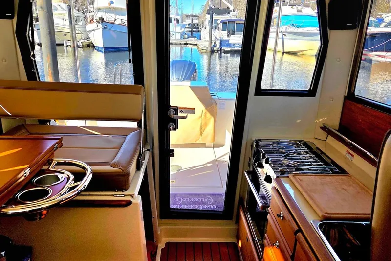 Slide: The Image of 2022 Ranger Tugs R-27 helm with Garmin navigation and wood accents. - 21