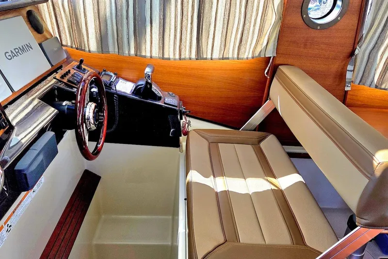 Slide: The Image of 2022 Ranger Tugs R-27 helm with Garmin navigation, joystick controls, and communication equipment. - 23