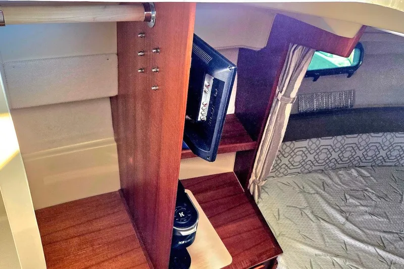 Slide: The Image of 2022 Ranger Tugs R-27 cabin interior with cozy bed and control panel. - 29