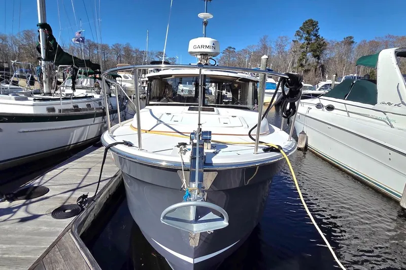 Slide: The Image of 2022 Ranger Tugs R-27 docked at marina, front view with clear blue sky. - 3
