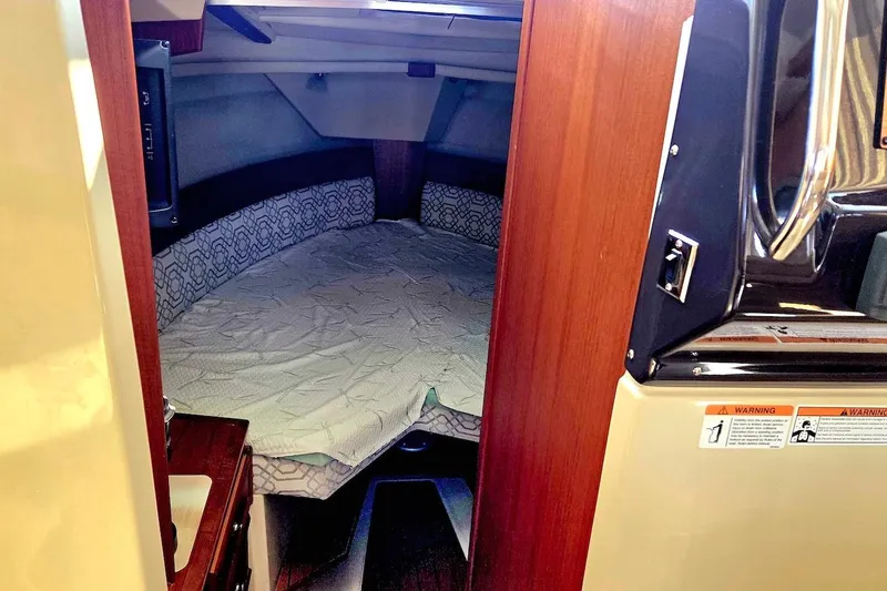 Slide: The Image of 2022 Ranger Tugs R-27 bathroom with modern sink, wooden accents, and porthole window. - 31