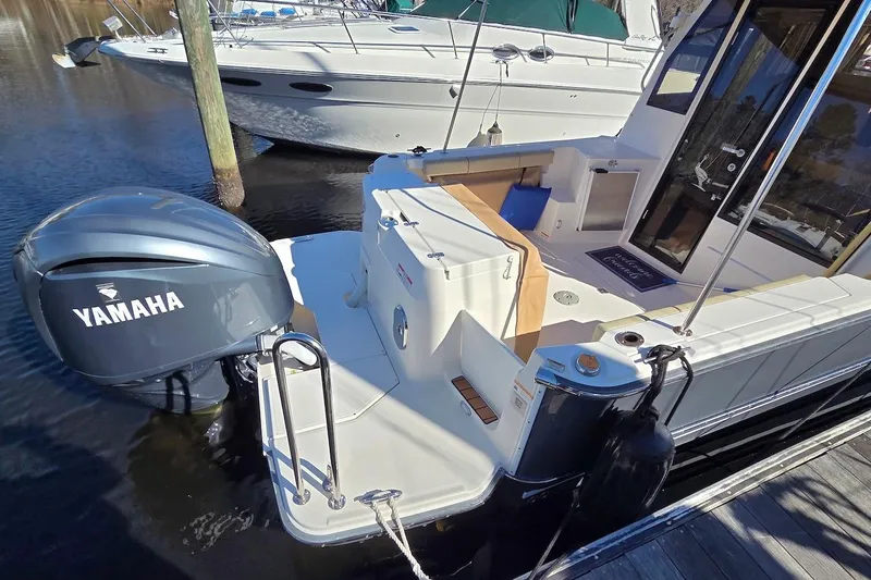 Slide: The Image of 2022 Ranger Tugs R-27 boat deck with seating and dock view. - 9