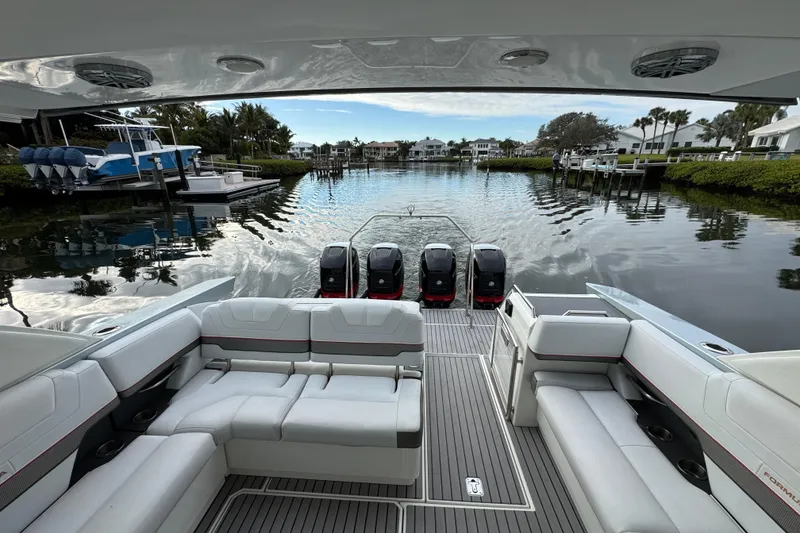 Slide: The Image of 2018 Formula 430 Super Sport Crossover boat with luxurious seating and powerful engines in a scenic marina. - 8