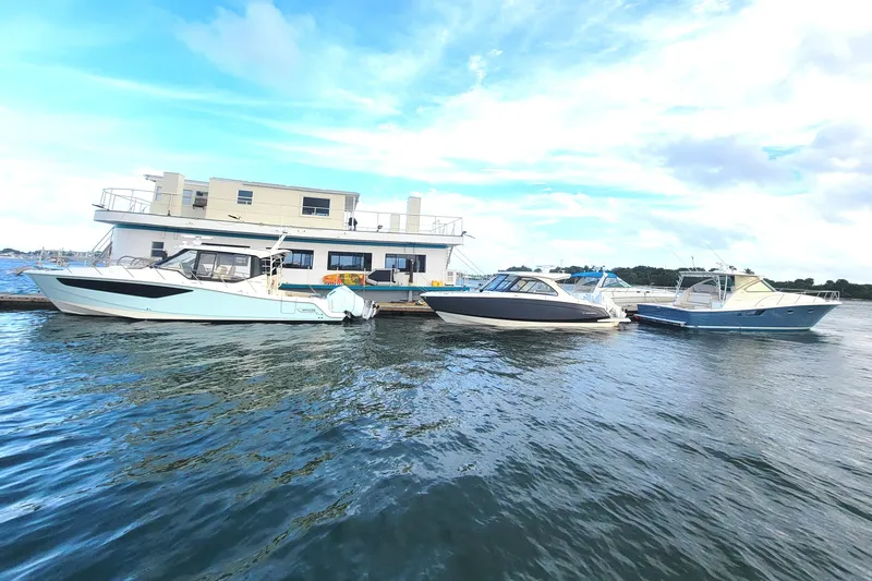 Slide: The Image of Floating home with three boats docked, under a clear blue sky. - 0