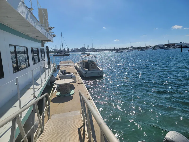 Slide: The Image of Floating home docked by the water, Custom model, 2003, with boats and clear blue sky. - 30