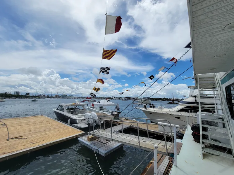 Slide: The Image of Floating home docked with boats, colorful flags, and a scenic waterfront view. - 35