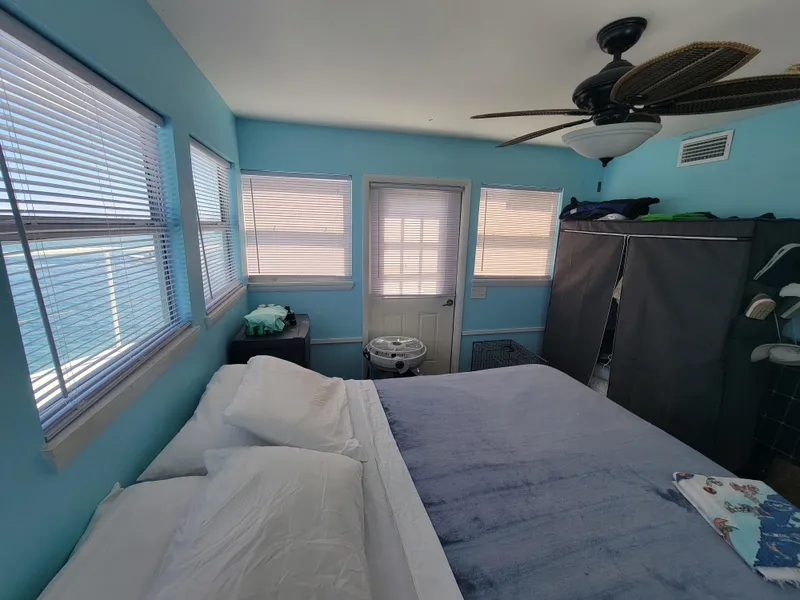 Slide: The Image of Cozy bedroom in a 2003 custom floating home with blue walls and ceiling fan. - 49