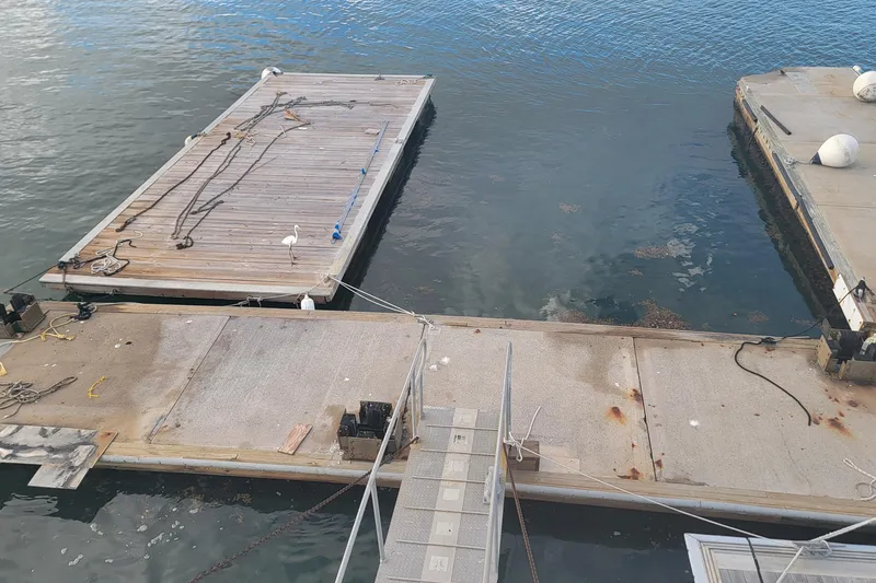 Slide: The Image of Floating marina with wooden docks and ropes, featuring a bird, 2003 Custom model. - 70