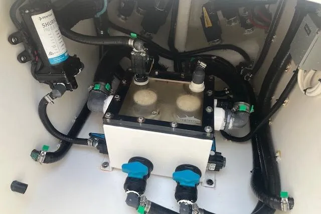 Slide: The Image of 2024 Contender 32 ST boat plumbing system with Shurflo pump and connected hoses. - 17