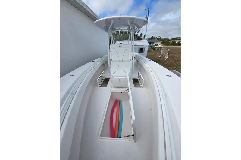 Slide: The Image of 2024 Contender 32 ST boat interior with open storage compartments and colorful pool noodles. - 34