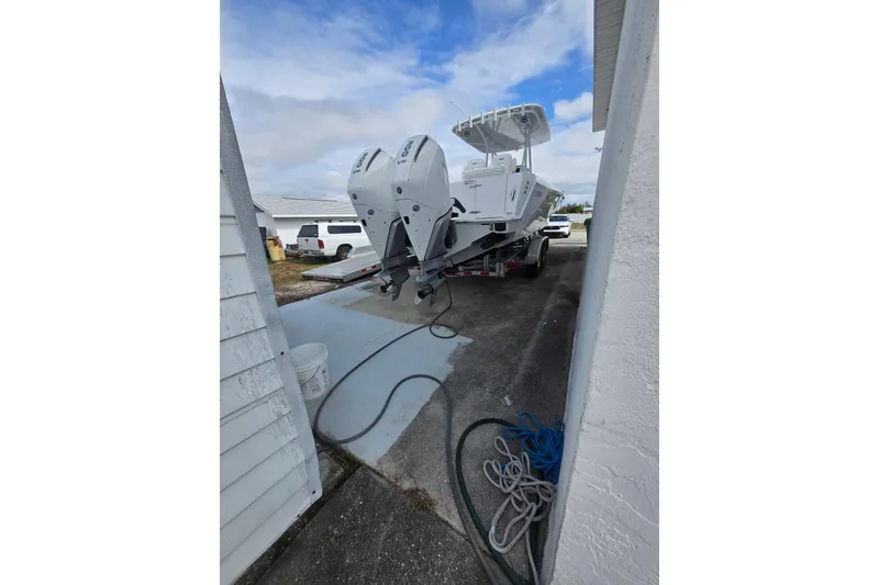 Slide: The Image of 2024 Contender 32 ST boat with dual engines on a trailer in a driveway. - 35