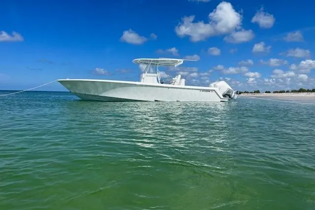 Slide: The Image of 2024 Contender 32 ST boat anchored in clear blue water under a sunny sky. - 4