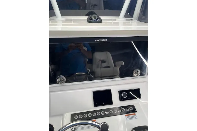 Slide: The Image of 2024 Contender 32 ST boat dashboard with modern controls and steering wheel. - 8