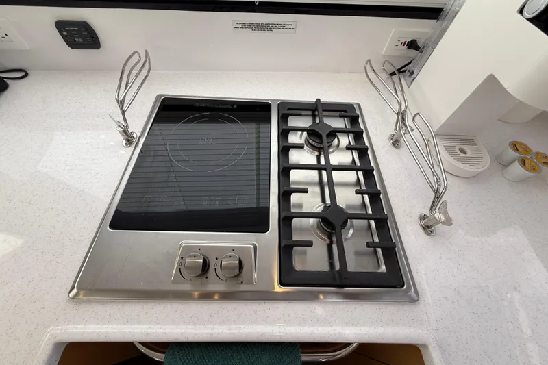 Slide: The Image of Modern kitchen stove on 2024 Seawind 1370 yacht, featuring gas burners and induction cooktop. - 21