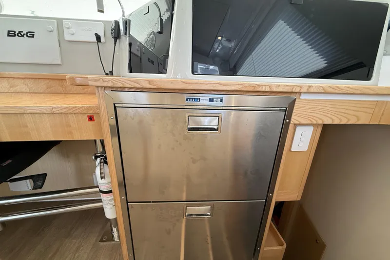 Slide: The Image of 2024 Seawind 1370 yacht interior with stainless steel appliances and wooden cabinetry. - 23