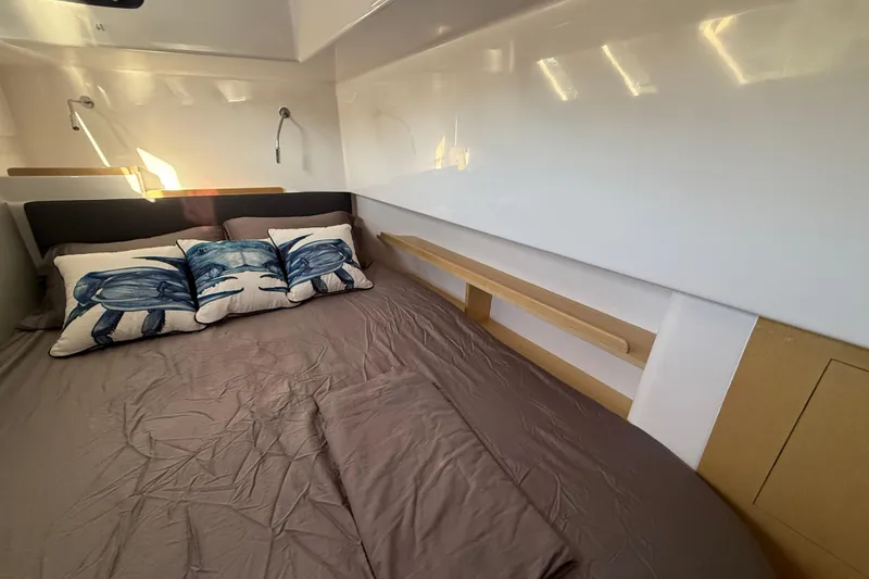 Slide: The Image of 2024 Seawind 1370 cabin interior with cozy bed and decorative pillows. - 26