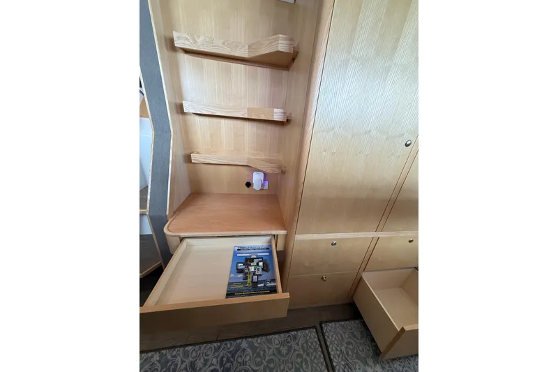 Slide: The Image of 2024 Seawind 1370 interior with wooden shelves and open drawers. - 29