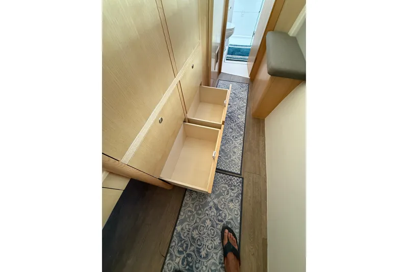 Slide: The Image of 2024 Seawind 1370 interior with open wooden drawers and patterned carpet. - 34