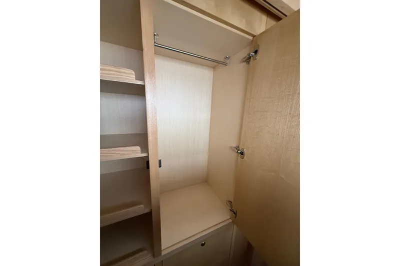 Slide: The Image of 2024 Seawind 1370 interior closet with wooden shelves and hanging rod. - 35